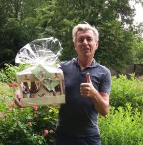 Foto van Paul Michiels die een geschenkpakket van Triple Trezeke krijgt