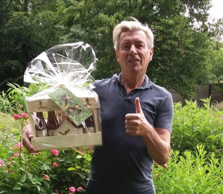 Foto van Paul Michiels die een geschenkpakket van Triple Trezeke krijgt